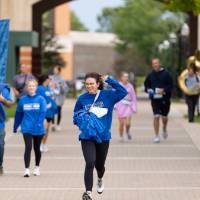 Participants nearing finish line celebrating with one hand in the air